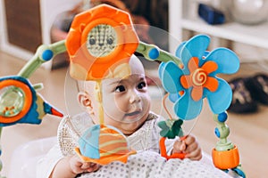 Cute chubby baby playing with colorful toys. Sweet infant at home