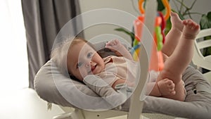 Cute close-up of baby lying in cradle and holding teething ring, adorable baby 5 month old baby