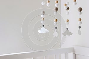 Cute cloud mobile hanging on crib in nursery room