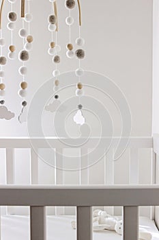 Cute cloud mobile hanging on crib in nursery room