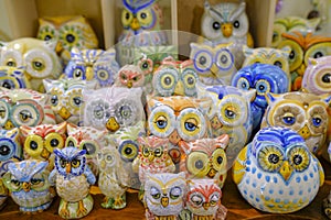 Cute colorful ceramic owl toys of different sizes close-up. souvenir shop in the market