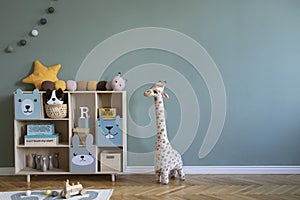 Cute composition of stylish scandi child room interior design with armchair, wooden shelf, plush giraffe, toys.