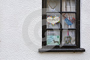 Cute cottage black window with decorative signs on white painted
