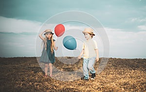 Cute couple with balloons. Adorable kids having fun. While having fun outdoors. Emotions on the face. Close friends