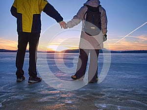 Cute couple in bay of frozen sea. They hold together at pond