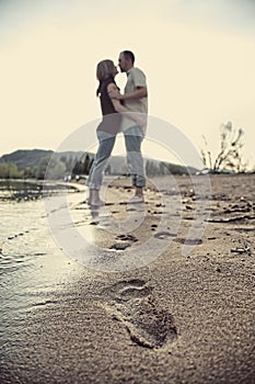 Cute couple on beach with footprints in sand