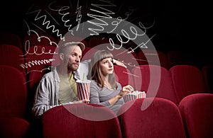 Cute couple in cinema watching movie