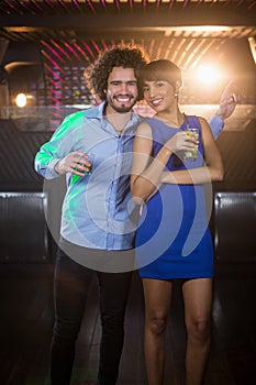 Cute couple dancing together on dance floor while having drink