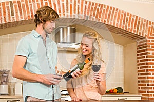 Cute couple enjoying a glass of wine and reading the bottle