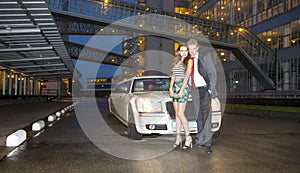Cute couple in front of a limousine