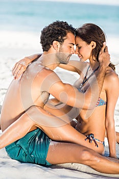 Cute couple hugging sitting on the beach