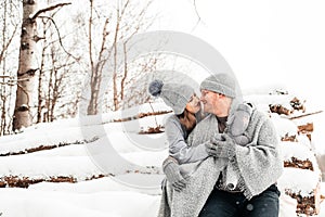 Cute couple in love sitting on the log, winter forest. Artwork.
