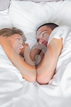 Cute couple lying together in bed