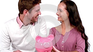 Cute couple with moving box and piggy bank