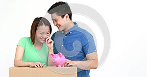Cute couple with moving box and piggy bank