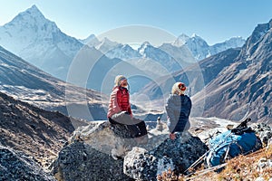 Cute Couple resting on the Everest Base Camp trekking route near Dughla 4620m. Man and woman enjoying a rest.They left Backpacks