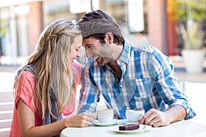 Cute couple sitting at a cafe head to head