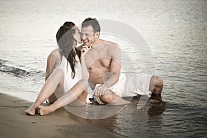 Cute couple sitting in shallow water together.