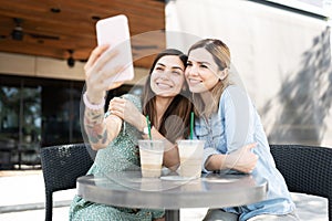 Cute couple of women staking a selfie with phone