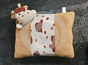Cute cow stuffed pillows on surface carpet as a background