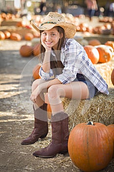 Cute Cowgirl in Hat and Boots at the Pumpkin Patch