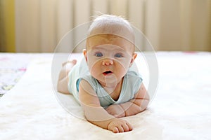 Cute crawling baby girl on a bed at home
