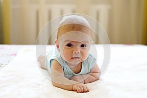 Cute crawling baby girl on a bed at home