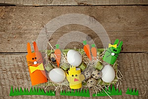 Cute creative photo with easter eggs, papaer cratf diy chiken and the Easter Bunny, holiday springtime concept, copy space