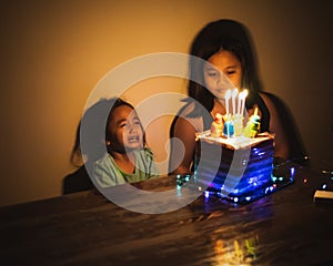 Cute crying little  girl celebrating birthday. Child unhappy for no reason indoor. Photo may contain noise due to low light