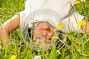 Cute curly boy stands upside down in field