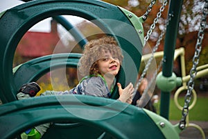 Cute curly haired  posing on interesting swing