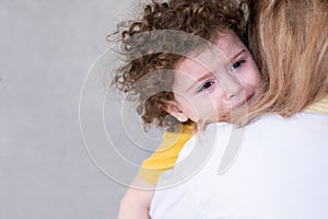 cute curly little child girl crying hug her mother