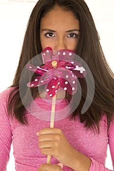 Cute dark complected teen girl holding a toy windmill