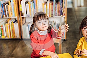 Cute dark-eyed girl with Down syndrome taking her glasses off