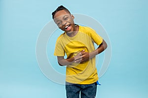 Cute dark-skinned boy laughing hard and looking enjoyed photo