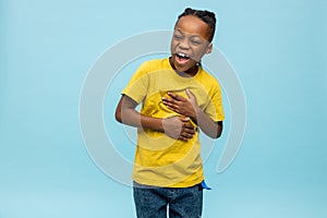 Cute dark-skinned boy laughing hard and looking enjoyed photo