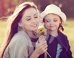 Cute daughter present her mother the yellow flowers and happy mo