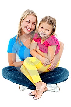 Cute daughter sitting in mother's lap