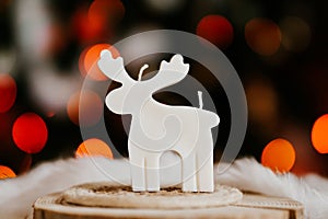 Cute deer shaped soy wax candle, Christmas lights in the background