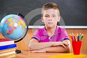 Cute diligent boy sitting in classroom photo