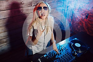 Cute dj woman having fun playing music at club party