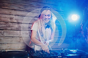 Cute dj woman having fun playing music at club party