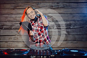 Cute dj woman having fun playing music at club party