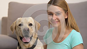 Cute dog and happy young woman looking in camera, pet companionship, best friend