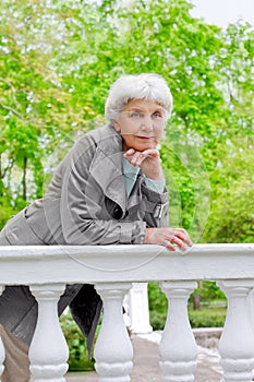 Cute elderly woman senior on the beautiful white verandah