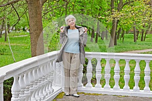 Cute elderly woman senior on the verandah in the park