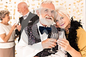 Elegant senior couple toasting with champagne during New Year`s Eve