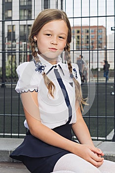 Cute elementary schoolgirl in uniform at playground
