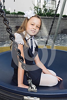 Cute elementary schoolgirl in uniform at playground photo