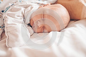 Cute emotional newborn funny little baby boy sleeping in crib. Baby goods packaging template. Healthy child, concept of hospital
